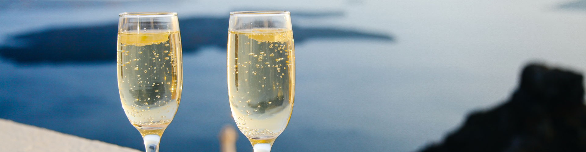 two glasses of champagne overlooking sea in distance