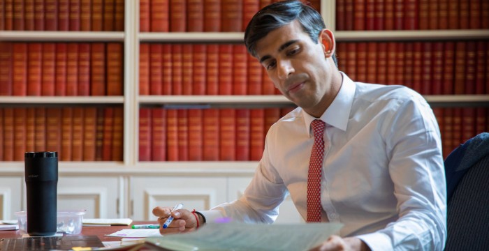Rishi Sunak in a library of leather bound red books